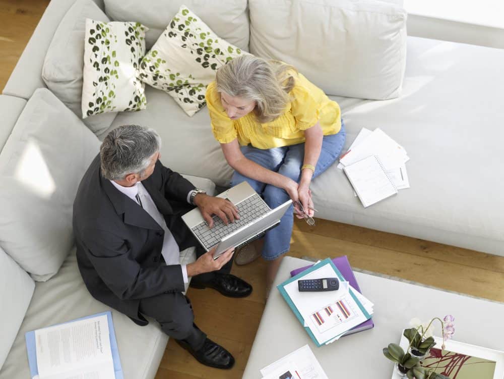 Business coach sitting in living room with woman discussing finances.