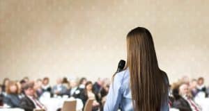 woman speaking at a conference to an audience