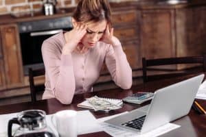woman with a negative mindset about money working on creating a budget